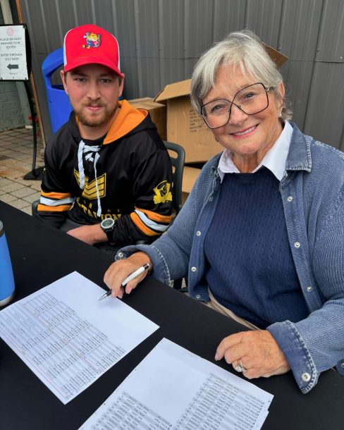 A man and a woman seated at a registration table.