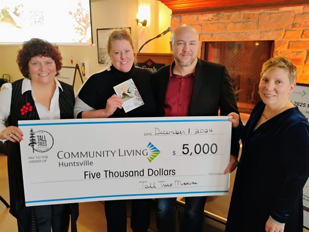 4 smiling people hold an oversized cheque for $5,000 to Community Living Huntsville from Tall Trees Muskoka.